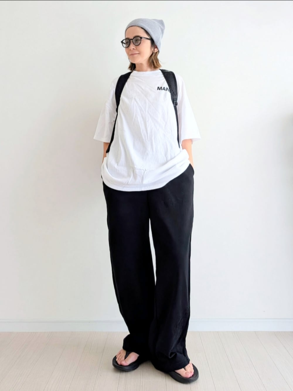 ブラック系のその他パンツ、ホワイト系のTシャツ/カットソー、ブラック系のサンダルを着用したレディースの夏コーディネートの4枚目の写真