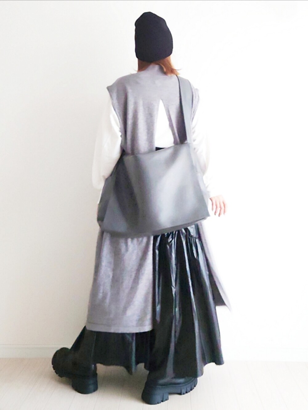 グレー系のワンピース、グレー系のショルダーバッグ、ブラック系のブーツを着用したレディースの秋コーディネートの5枚目の写真