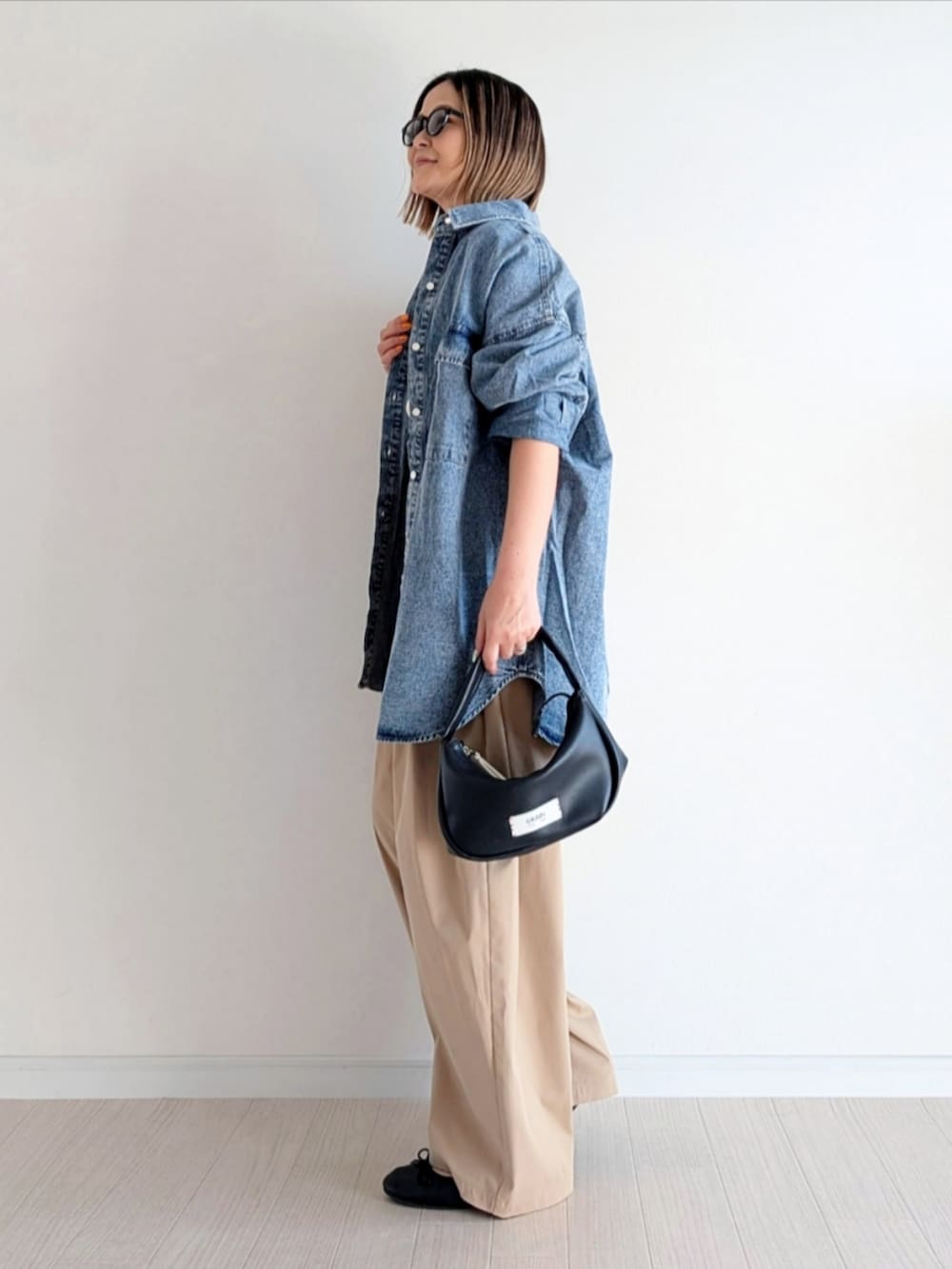 ベージュ系のチノパンツ、ブルー系のシャツ/ブラウス、ホワイト系のTシャツ/カットソーを着用したレディースの春コーディネートの2枚目の写真