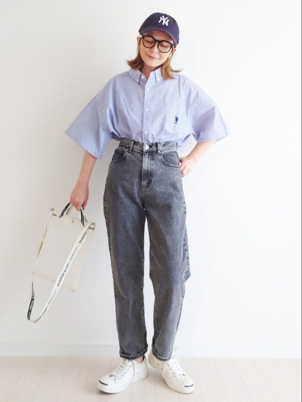 ブラック系のデニムパンツ、その他のショルダーバッグ、ホワイト系のスニーカーを着用したレディースの春コーディネートの3枚目の写真