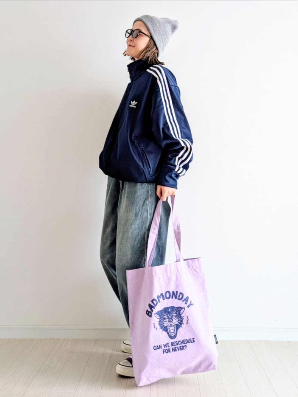 ブルー系のデニムパンツ、ブルー系のジャージ、パープル系のトートバッグを着用したレディースの秋コーディネートの2枚目の写真