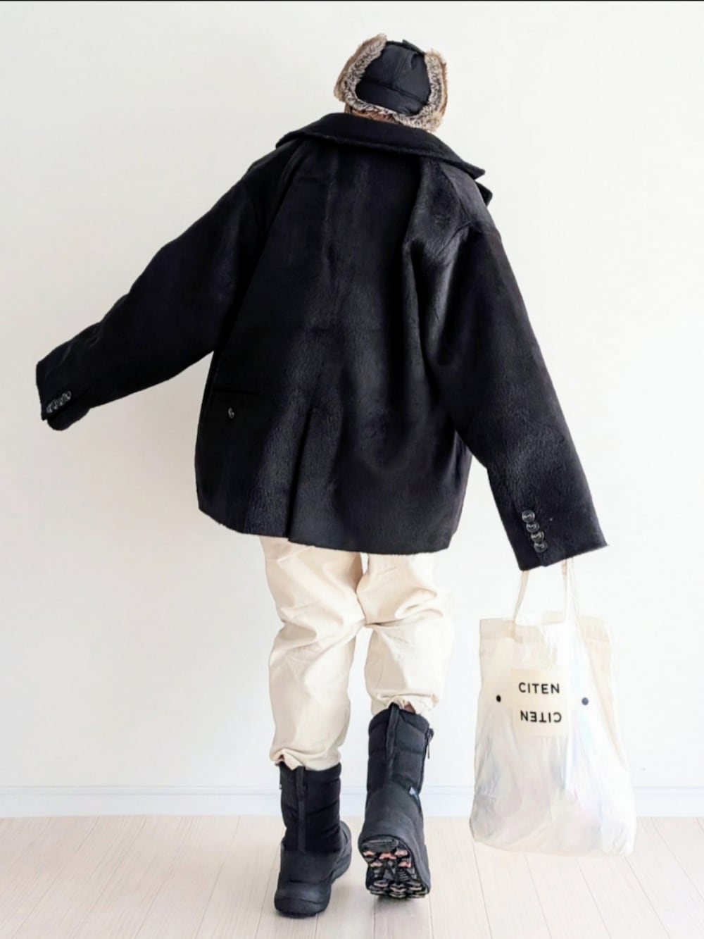 グレー系のニット/セーター、ブラック系のテーラードジャケット、ブラック系のブーツを着用したレディースの冬コーディネートの4枚目の写真