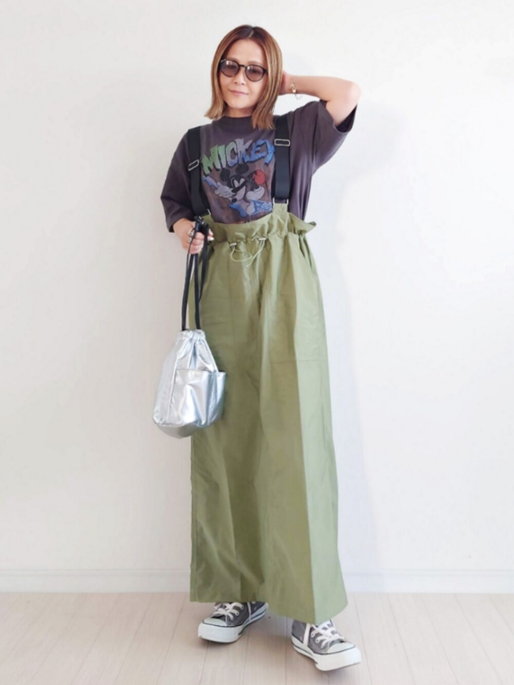 グレー系のTシャツ/カットソー、グリーン系のジャンパースカート、シルバー系のハンドバッグを着用したレディースの夏コーディネートの5枚目の写真