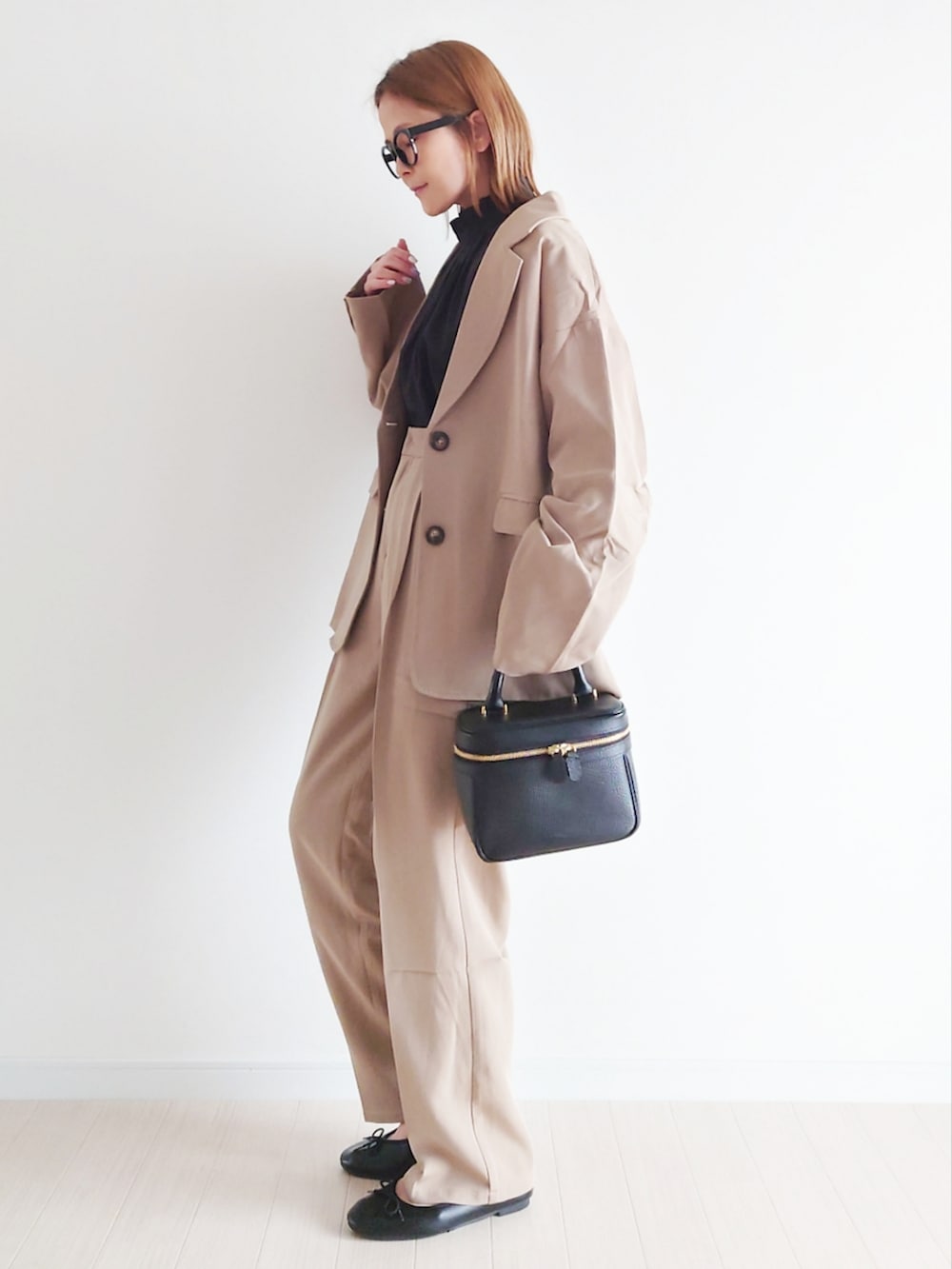 ベージュ系のセットアップ、ブラック系のシャツ/ブラウス、ブラック系のハンドバッグを着用したレディースの冬コーディネートの3枚目の写真