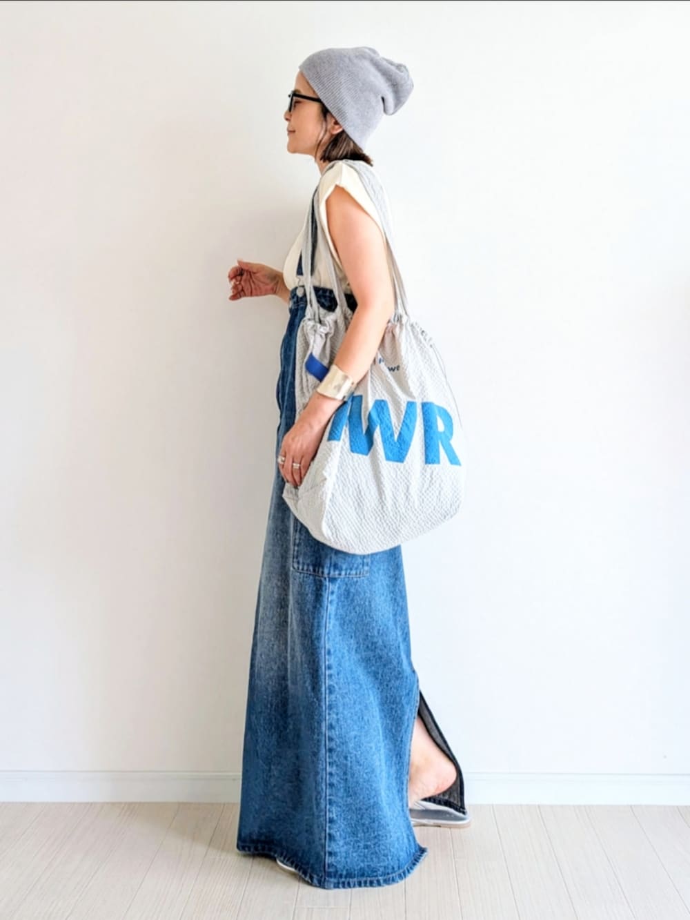 ブルー系のジャンパースカート、ホワイト系のTシャツ/カットソー、シルバー系のサンダルを着用したレディースの夏コーディネートの2枚目の写真