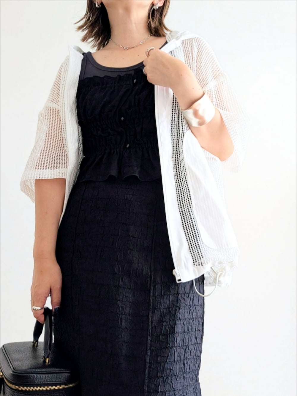 ブラック系のサンダル、ブラック系のワンピース、ホワイト系のパーカーを着用したレディースの夏コーディネートの4枚目の写真