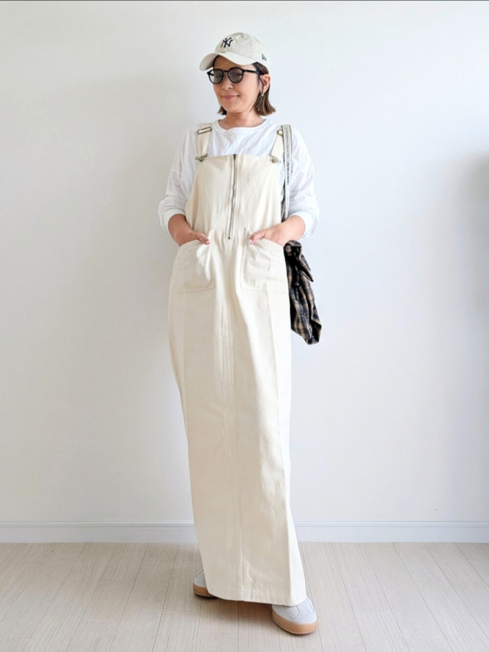 ホワイト系のジャンパースカート、ホワイト系のTシャツ/カットソー、ベージュ系のスニーカーを着用したレディースの秋コーディネートの5枚目の写真