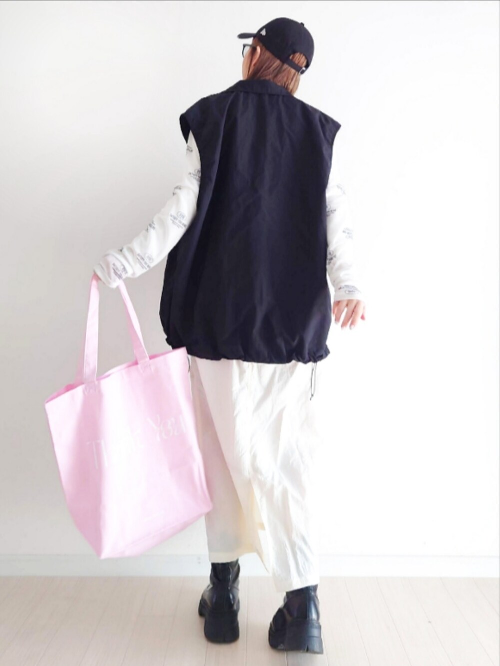 ホワイト系のスカート、ピンク系のエコバッグ/サブバッグ、ホワイト系のTシャツ/カットソーを着用したレディースの春コーディネートの4枚目の写真