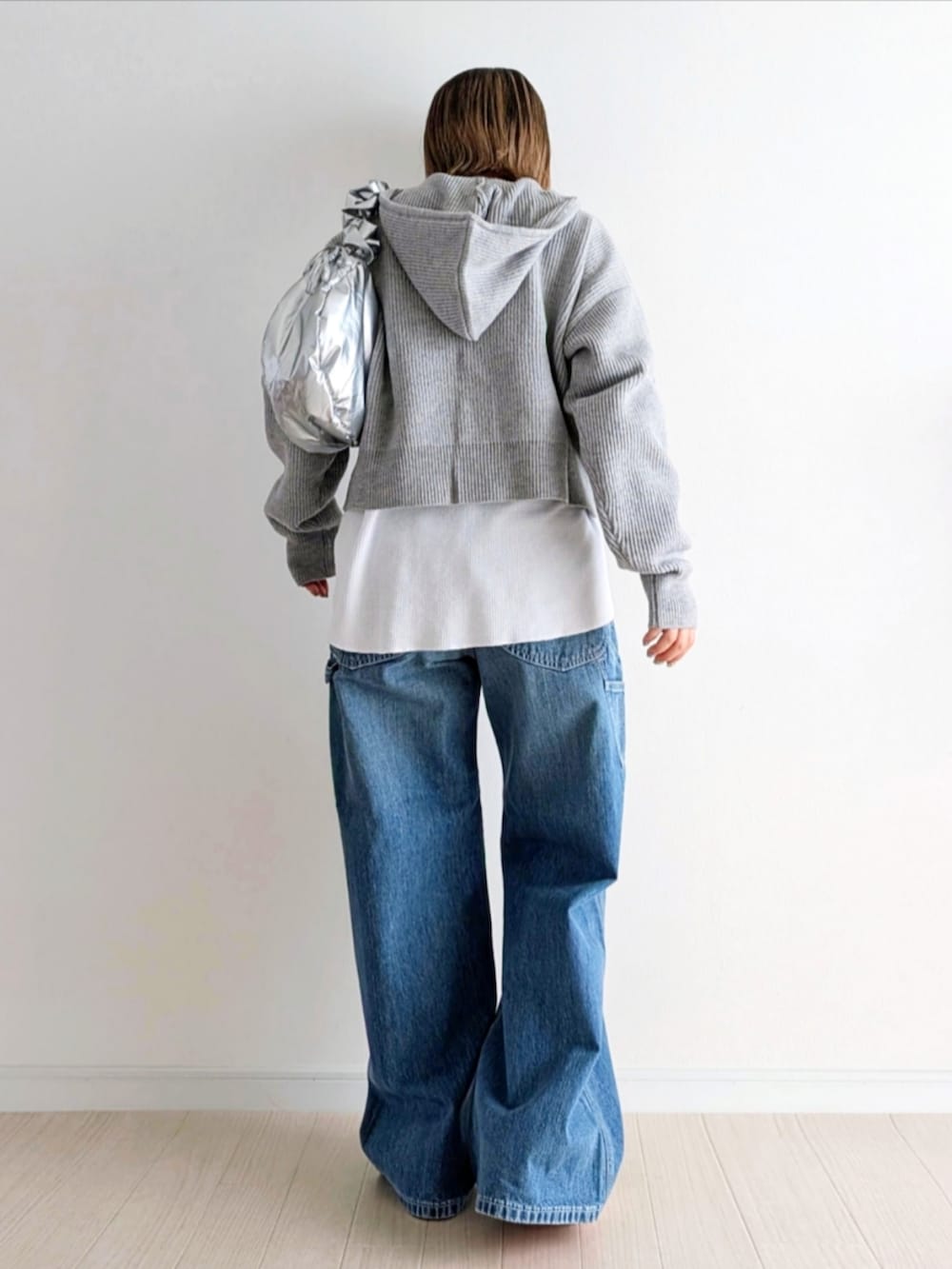 ブルー系のデニムパンツ、グレー系のパーカー、ピンク系のスニーカーを着用したレディースの冬コーディネートの3枚目の写真