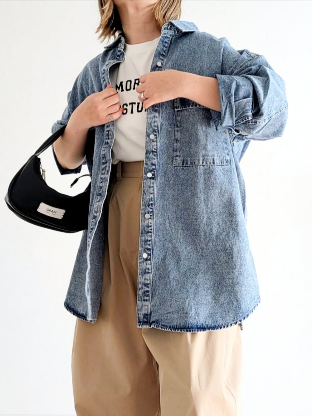 ベージュ系のチノパンツ、ブルー系のシャツ/ブラウス、ホワイト系のTシャツ/カットソーを着用したレディースの春コーディネートの5枚目の写真