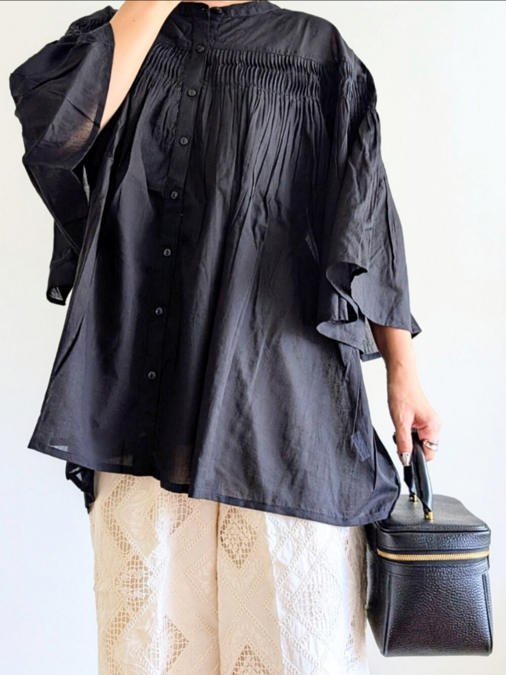 ブラック系のハンドバッグ、ブラック系のサンダル、ブラック系のシャツ/ブラウスを着用したレディースの夏コーディネートの5枚目の写真