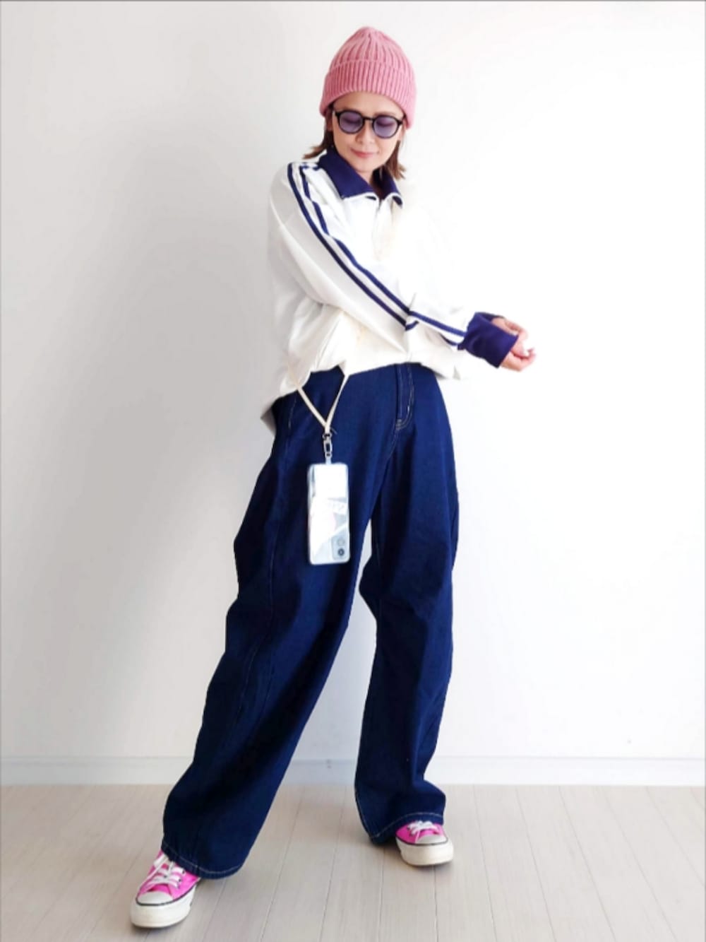 ホワイト系のジャージ、ブルー系のデニムパンツ、ピンク系のスニーカーを着用したレディースの冬コーディネートの5枚目の写真