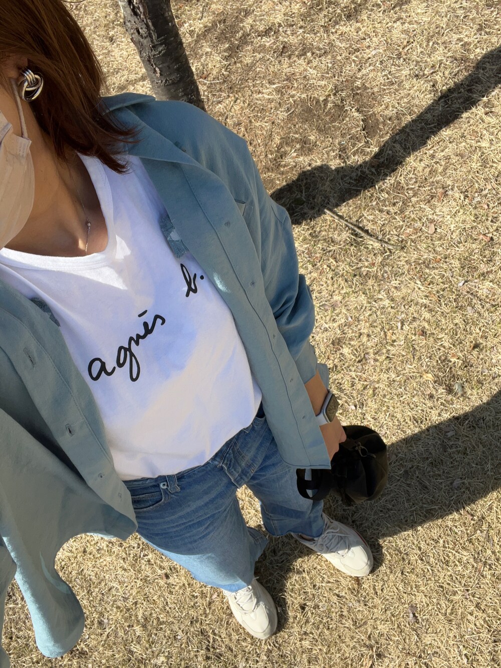 ブルー系のシャツ/ブラウス、ブラック系のショルダーバッグ、ブルー系のデニムパンツを着用したレディースの春コーディネートの2枚目の写真