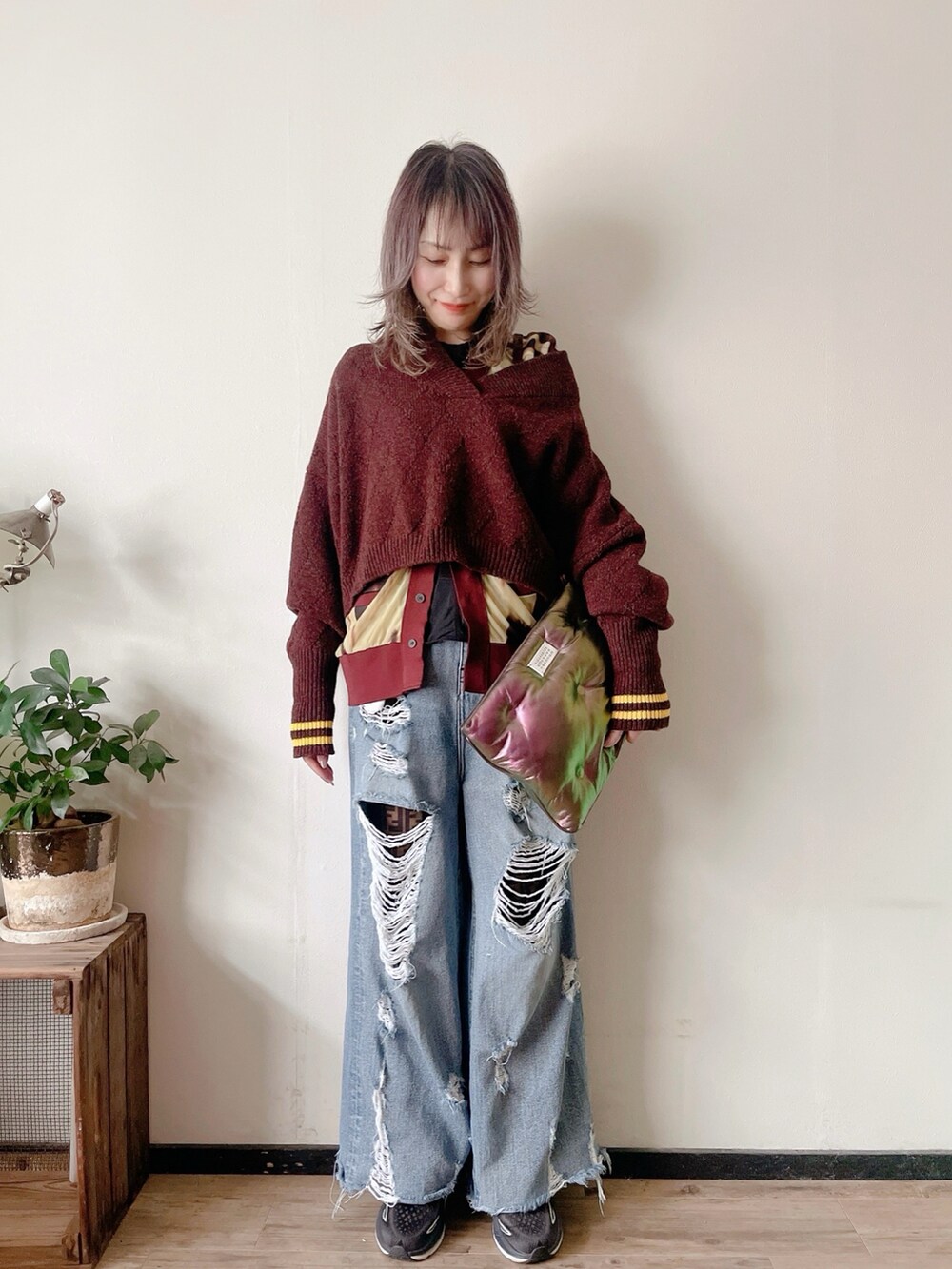 ブルー系のデニムパンツ、ブラック系のスニーカー、パープル系のニット/セーターを着用したレディースの秋コーディネートの3枚目の写真