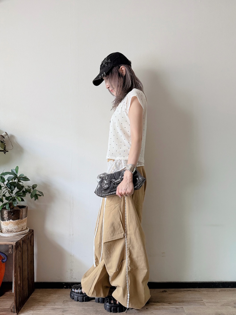 ホワイト系のTシャツ/カットソー、ベージュ系のその他パンツ、ブラック系のサンダルを着用したレディースの夏コーディネートの2枚目の写真