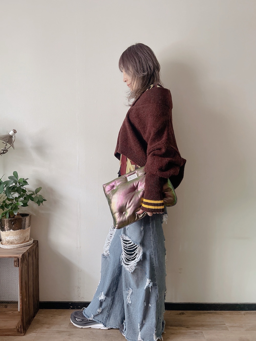 ブルー系のデニムパンツ、ブラック系のスニーカー、パープル系のニット/セーターを着用したレディースの秋コーディネートの2枚目の写真