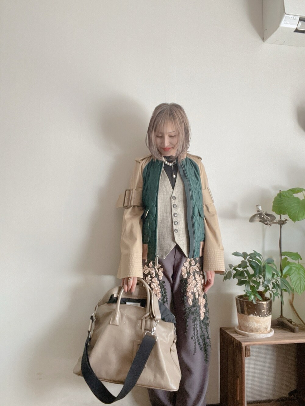 グレー系のベスト、ブラック系のトップス、グリーン系のジャケット/アウターを着用したレディースの春コーディネートの5枚目の写真