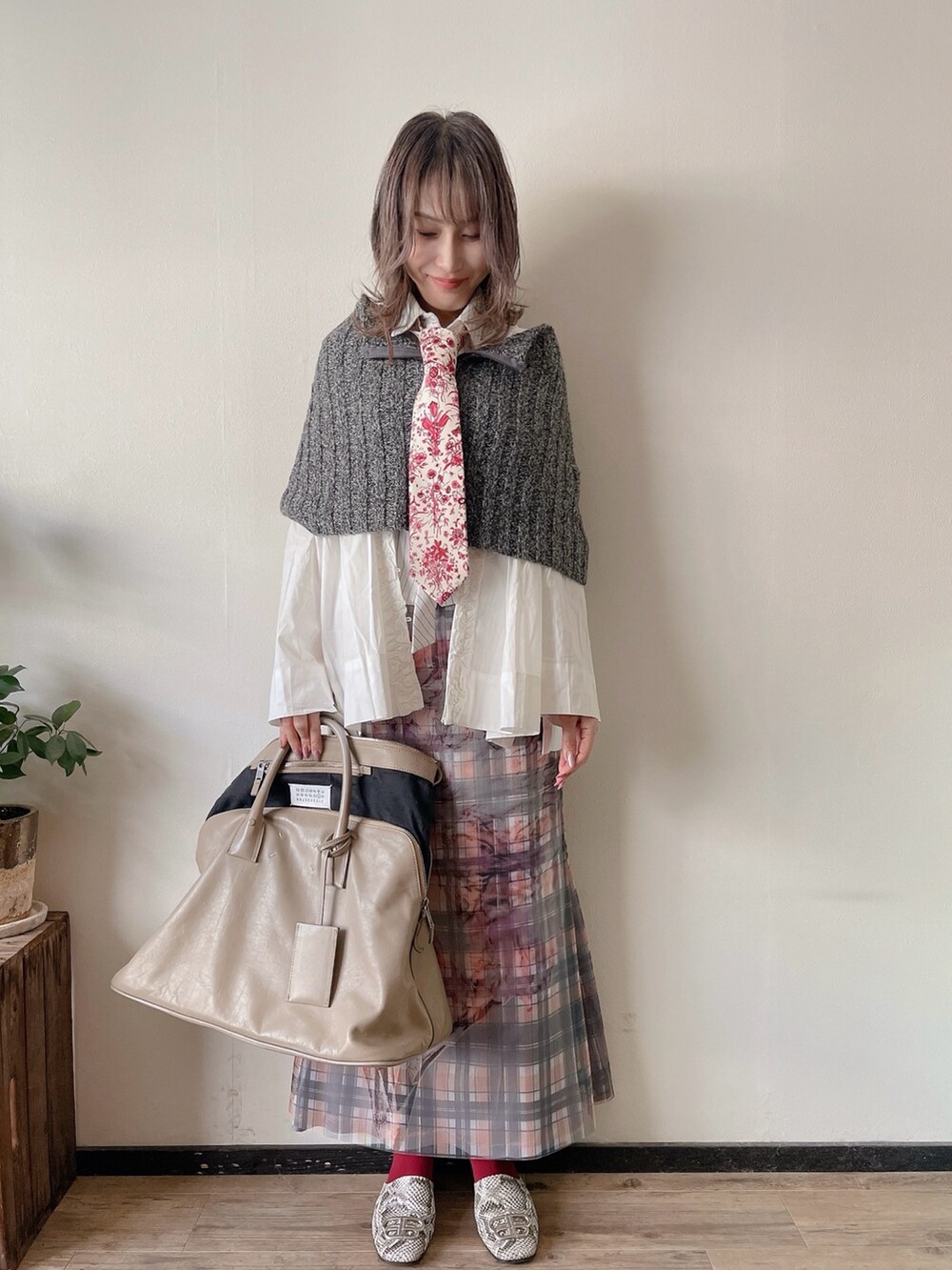 レッド系のネクタイ、グレー系のニット/セーター、ホワイト系のシャツ/ブラウスを着用したレディースの秋コーディネートの2枚目の写真