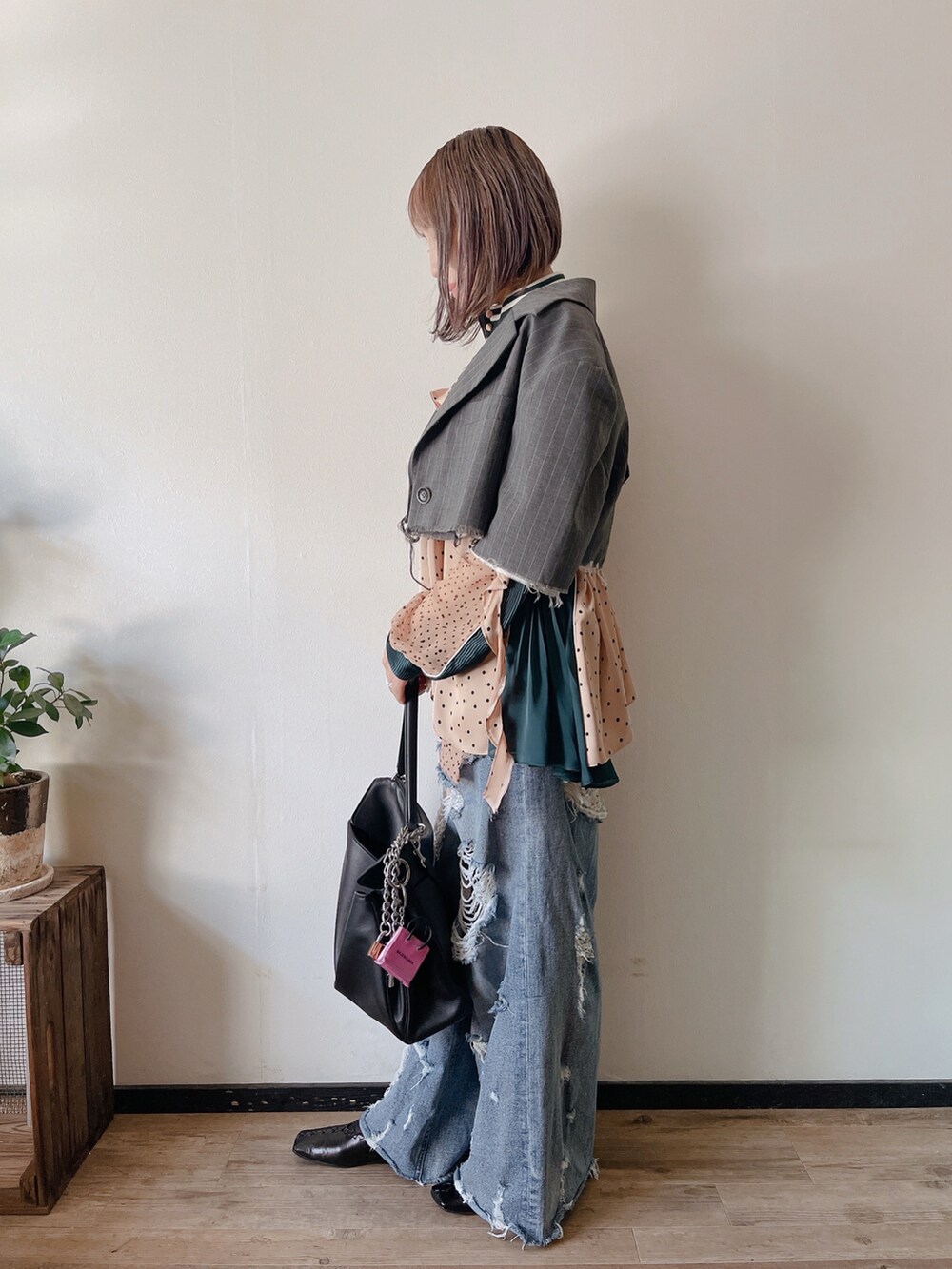 グレー系のテーラードジャケット、ブルー系のデニムパンツ、ブラック系のバッグを着用したレディースの秋コーディネートの2枚目の写真