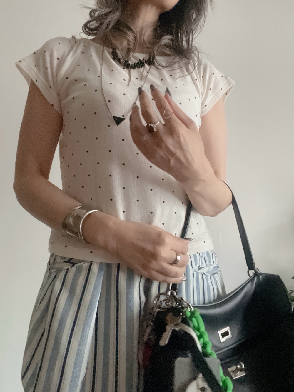 ホワイト系のTシャツ/カットソー、ブルー系のパンツ、ブラック系のバッグを着用したレディースの夏コーディネートの2枚目の写真