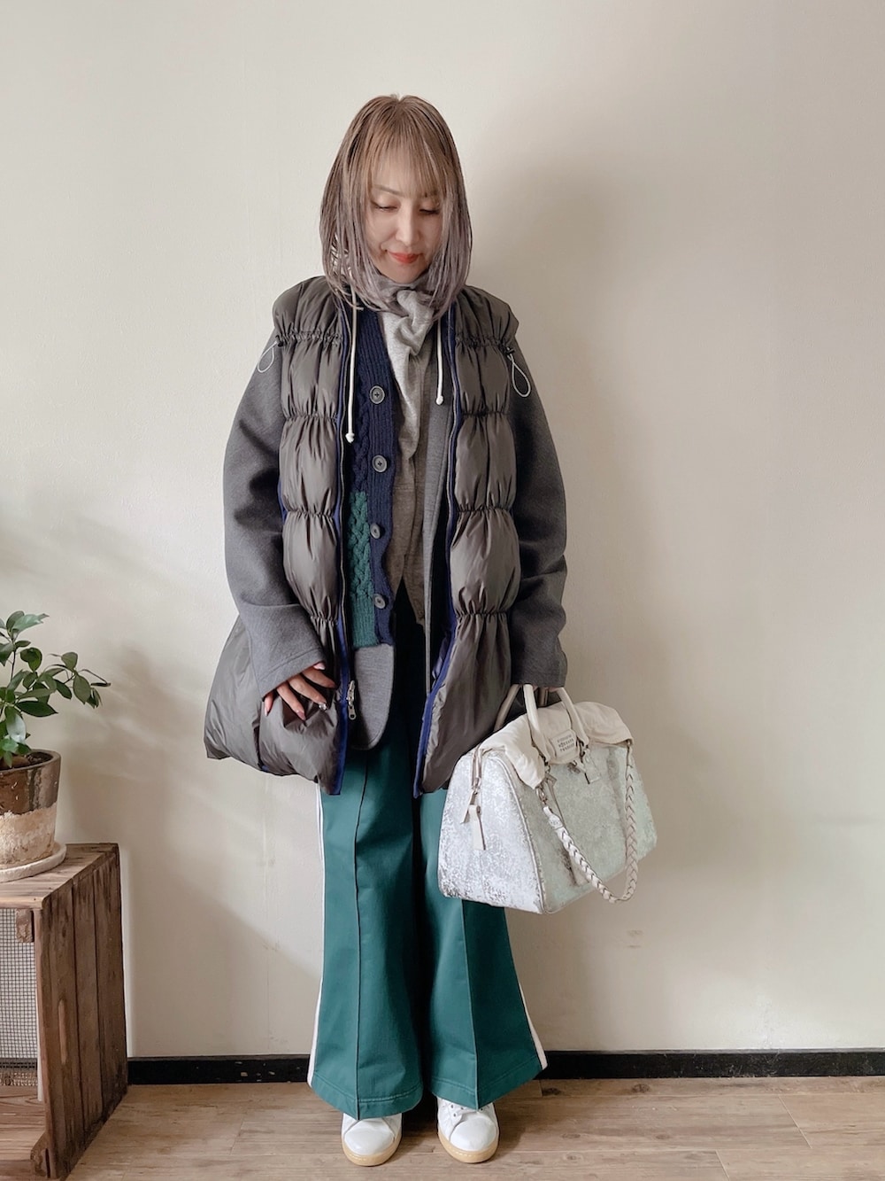 グリーン系のダウンベスト、グレー系のパーカー、グレー系のジャケット/アウターを着用したレディースの冬コーディネートの3枚目の写真