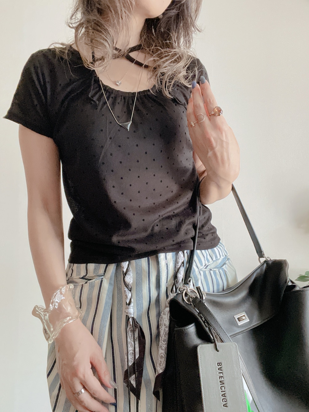 ブラック系のTシャツ/カットソー、ブルー系のパンツ、ブラック系のバッグを着用したレディースの夏コーディネートの2枚目の写真
