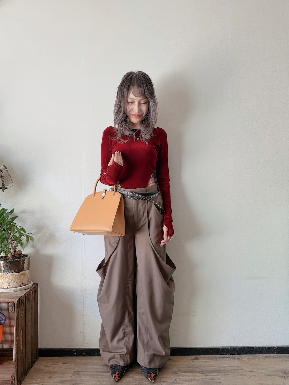 レッド系のトップス、ブラウン系のその他パンツ、その他のシューズを着用したレディースの秋コーディネートの3枚目の写真