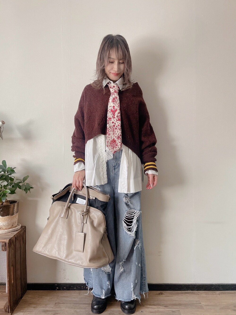 レッド系のネクタイ、パープル系のニット/セーター、ホワイト系のシャツ/ブラウスを着用したレディースの秋コーディネートの2枚目の写真