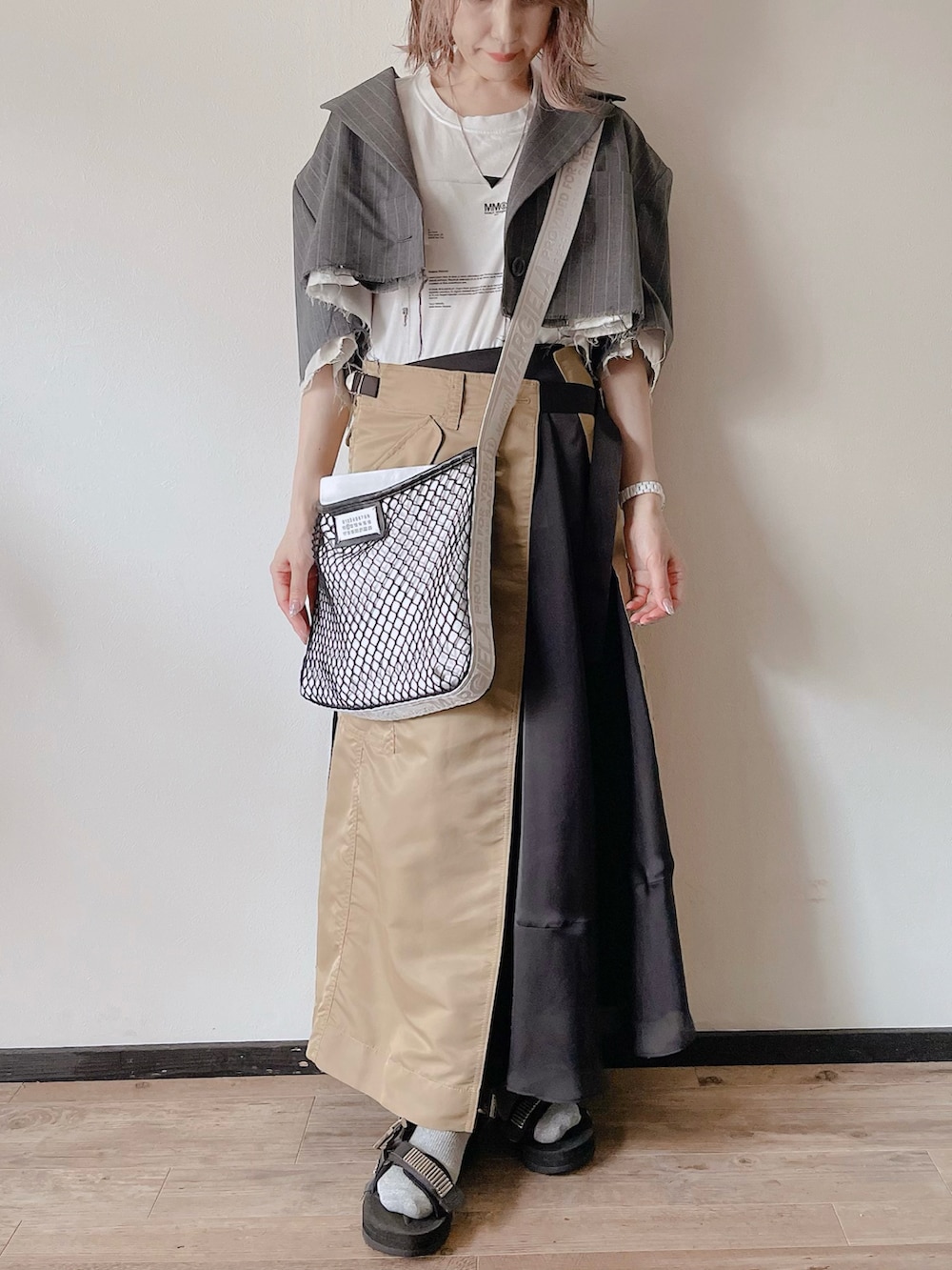 グレー系のテーラードジャケット、ホワイト系のショルダーバッグ、ブラック系のサンダルを着用したレディースの秋コーディネートの3枚目の写真