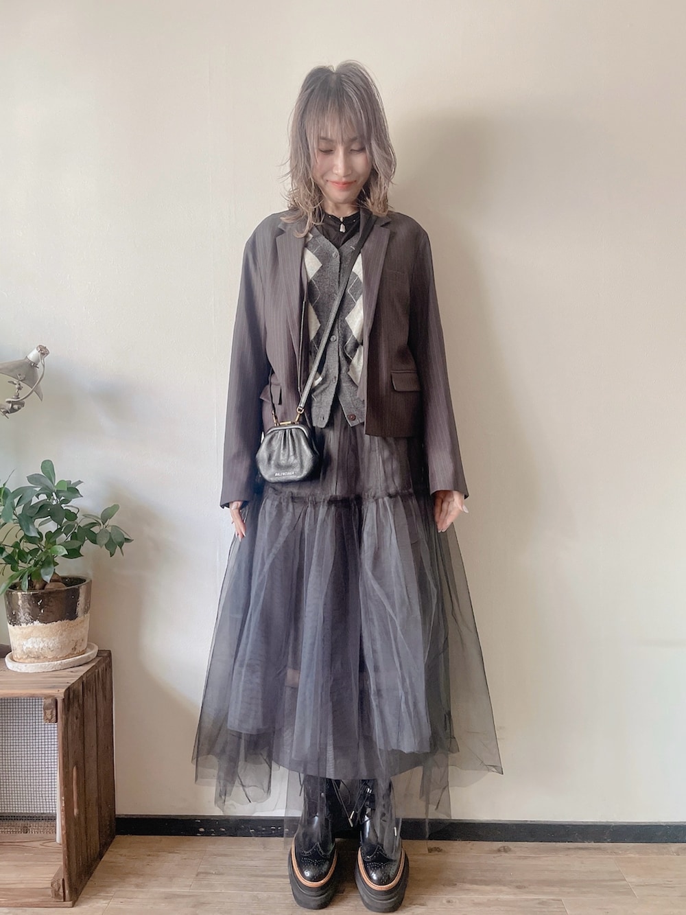 グレー系のその他アウター、ブラック系のスカート、グレー系のカーディガン/ボレロを着用したレディースの秋コーディネートの2枚目の写真