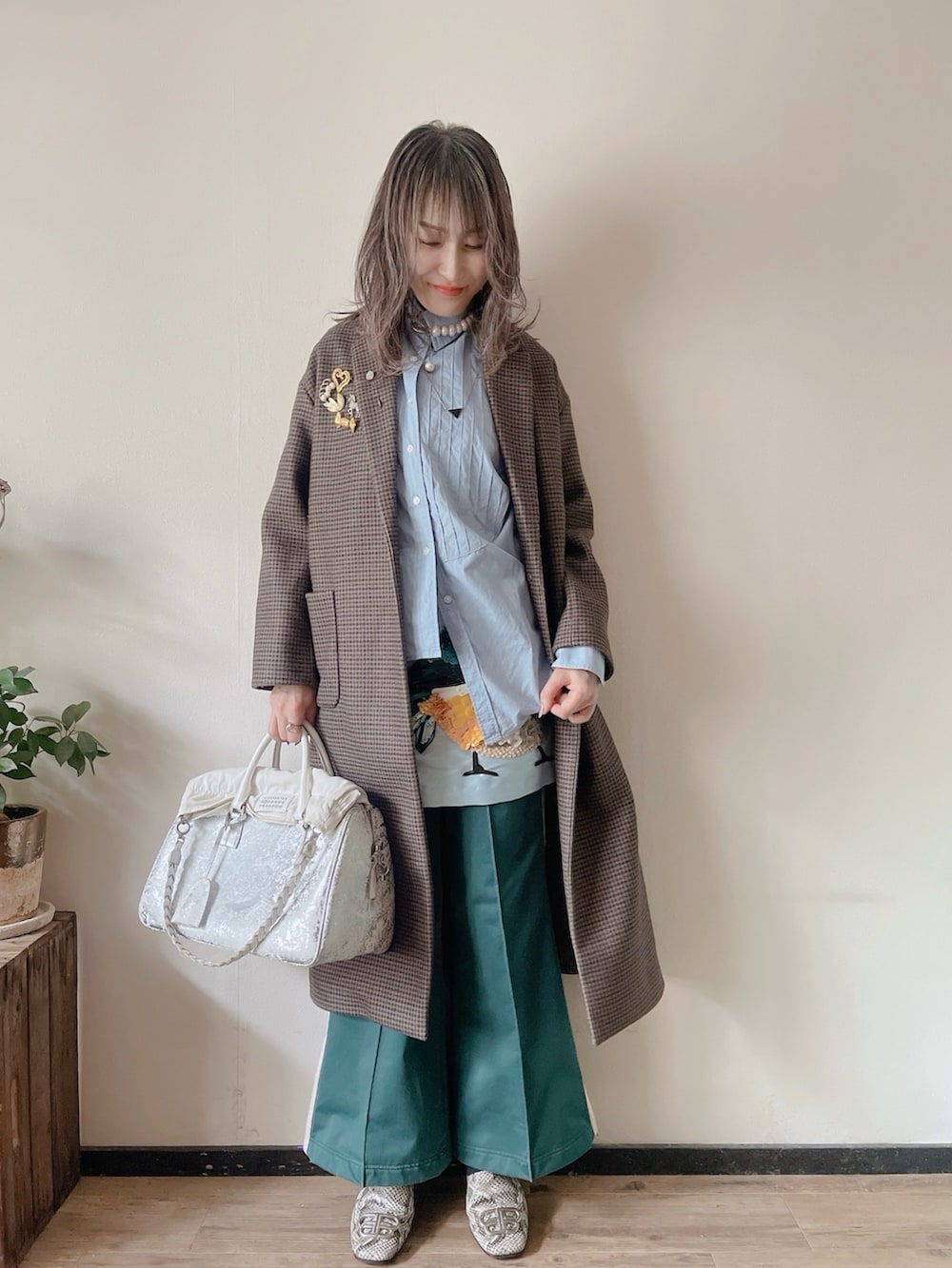 ホワイト系のシャツ/ブラウス、ブルー系のスカート、グリーン系のパンツを着用したレディースの冬コーディネートの2枚目の写真