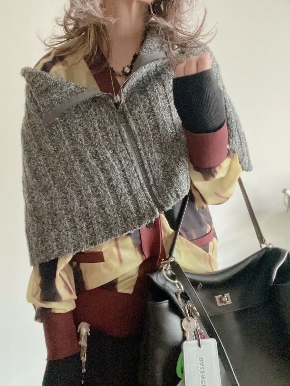 グレー系のニット/セーター、イエロー系のカーディガン/ボレロ、ブラック系のその他パンツを着用したレディースの冬コーディネートの2枚目の写真