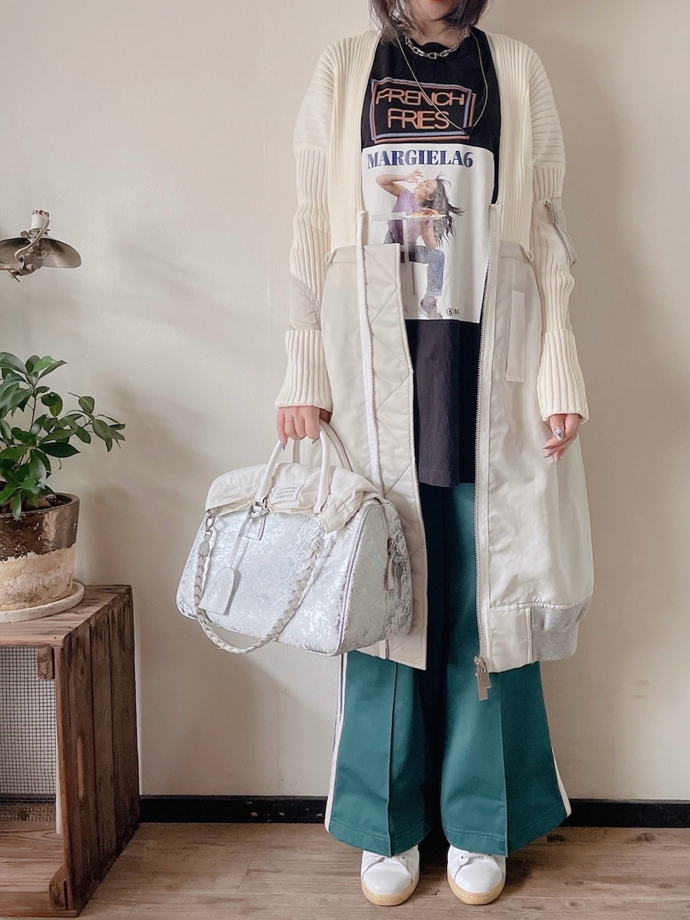 ブラック系のTシャツ/カットソー、グリーン系のパンツ、シルバー系のボストンバッグを着用したレディースの秋コーディネートの2枚目の写真