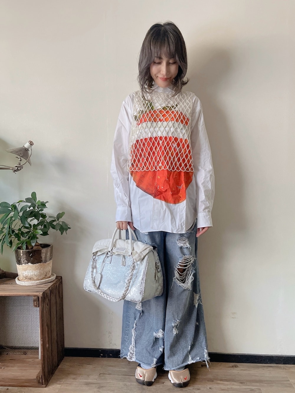 ホワイト系のその他トップス、ブルー系のデニムパンツ、シルバー系のボストンバッグを着用したレディースの秋コーディネートの2枚目の写真