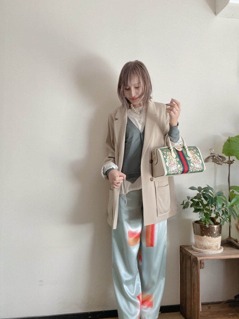 ホワイト系のサンダル、ベージュ系のテーラードジャケット、グリーン系のカーディガン/ボレロを着用したレディースの春コーディネートの2枚目の写真