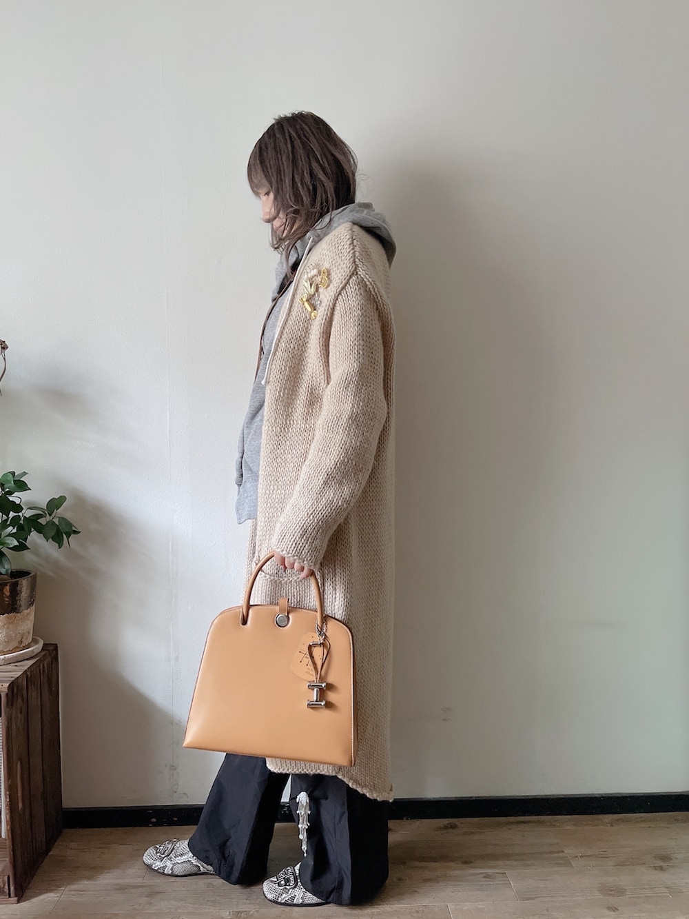 ブラック系のその他パンツ、ホワイト系のカーディガン/ボレロ、グレー系のパーカーを着用したレディースの冬コーディネートの3枚目の写真