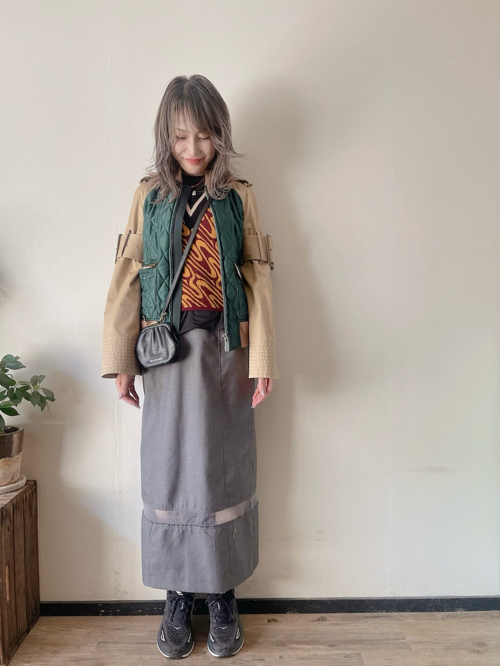 その他のベスト、ブラック系のスカート、ブラック系のスニーカーを着用したレディースの春コーディネートの2枚目の写真