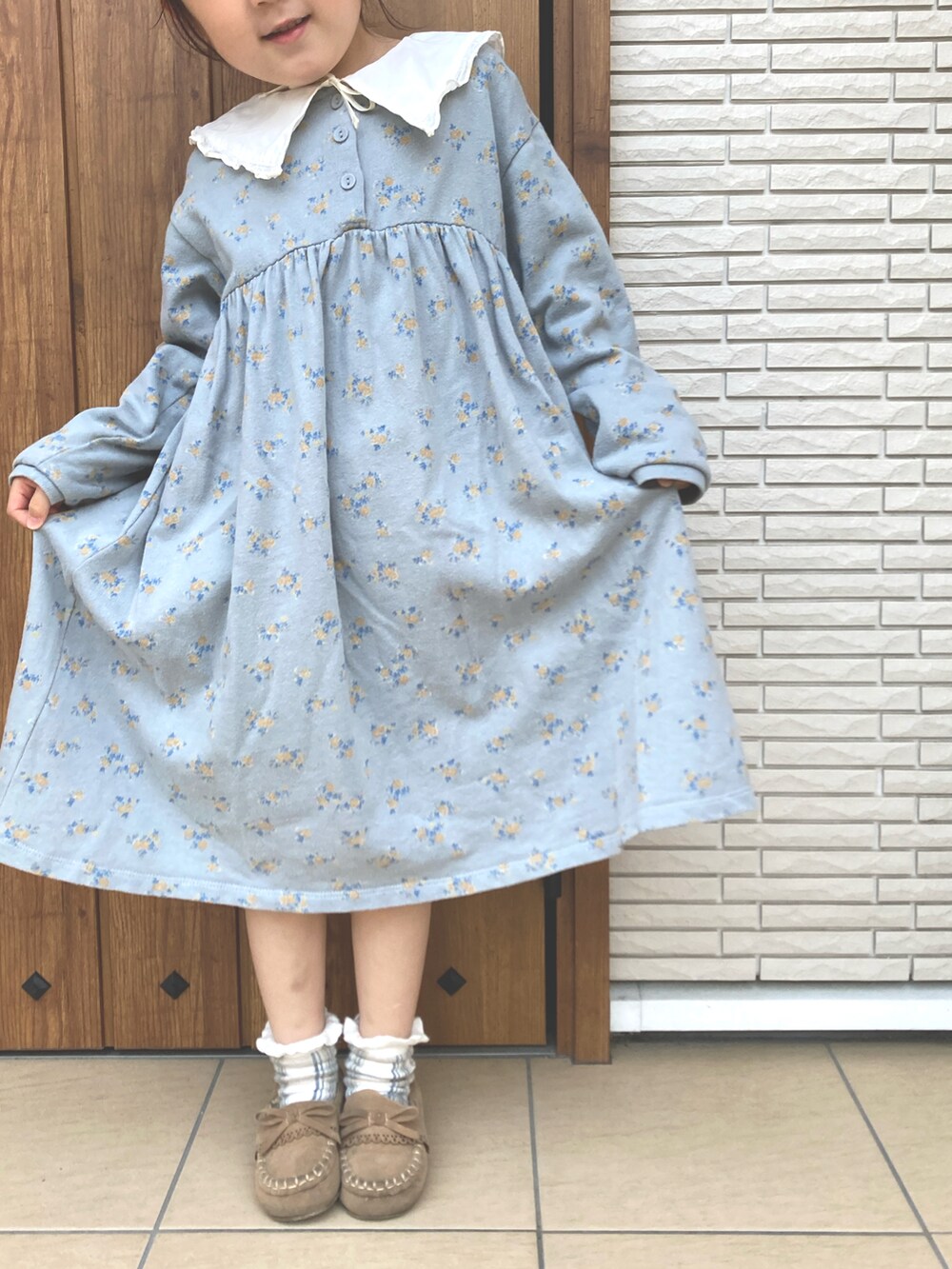 ブルー系のワンピースを着用したキッズの春コーディネートの2枚目の写真