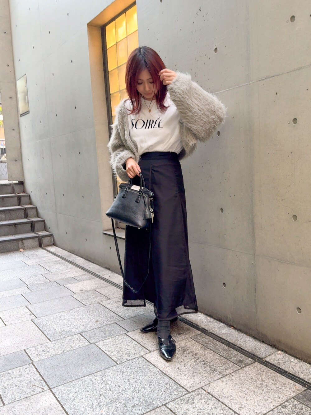 グレー系のカーディガン/ボレロ、ブラック系のスカート、ブラック系のパンプスを着用したレディースの秋コーディネートの2枚目の写真