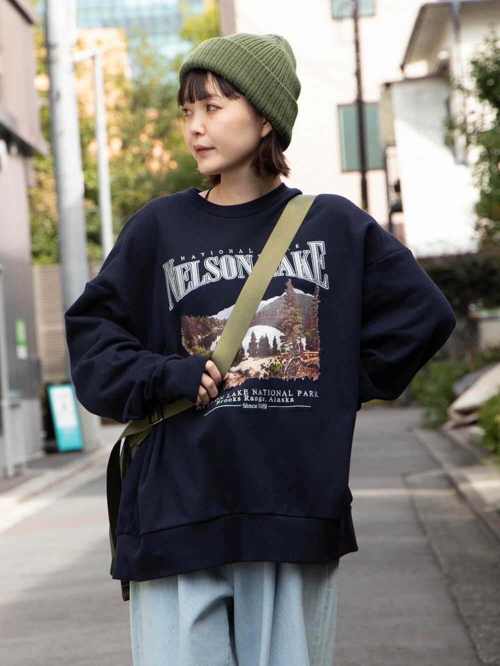 ブルー系のスウェット、グリーン系のショルダーバッグ、グリーン系のニットキャップ/ビーニーを着用したレディースの秋コーディネートの2枚目の写真