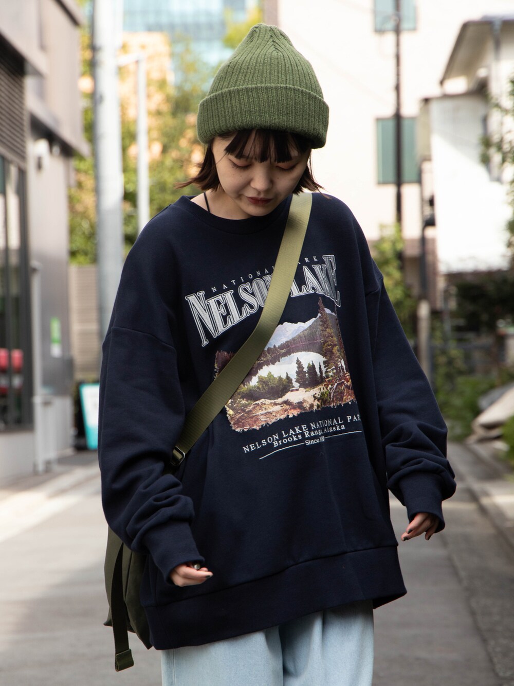 ブルー系のスウェット、グリーン系のショルダーバッグ、グリーン系のニットキャップ/ビーニーを着用したレディースの秋コーディネートの3枚目の写真