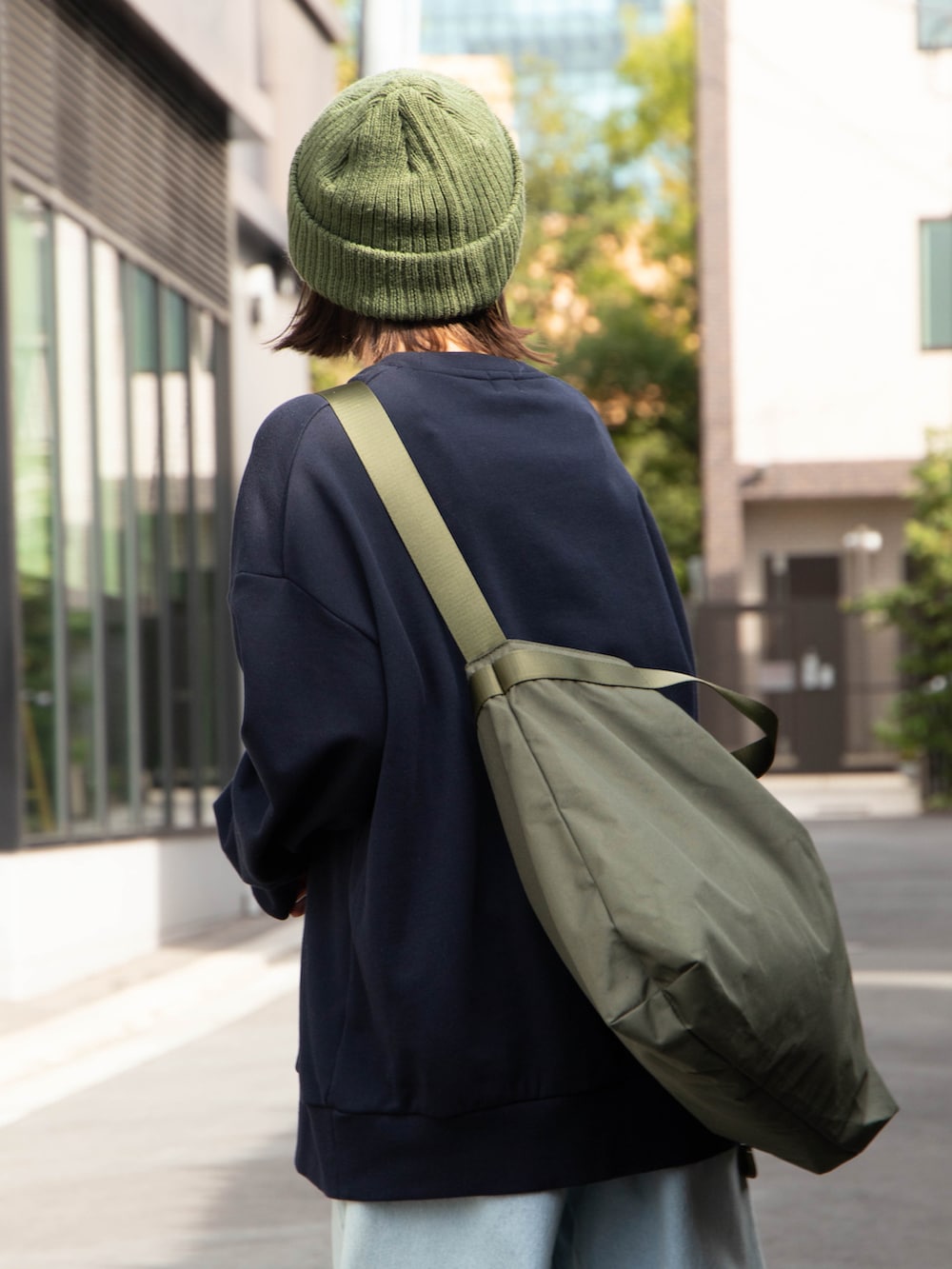 ブルー系のスウェット、グリーン系のショルダーバッグ、グリーン系のニットキャップ/ビーニーを着用したレディースの秋コーディネートの4枚目の写真