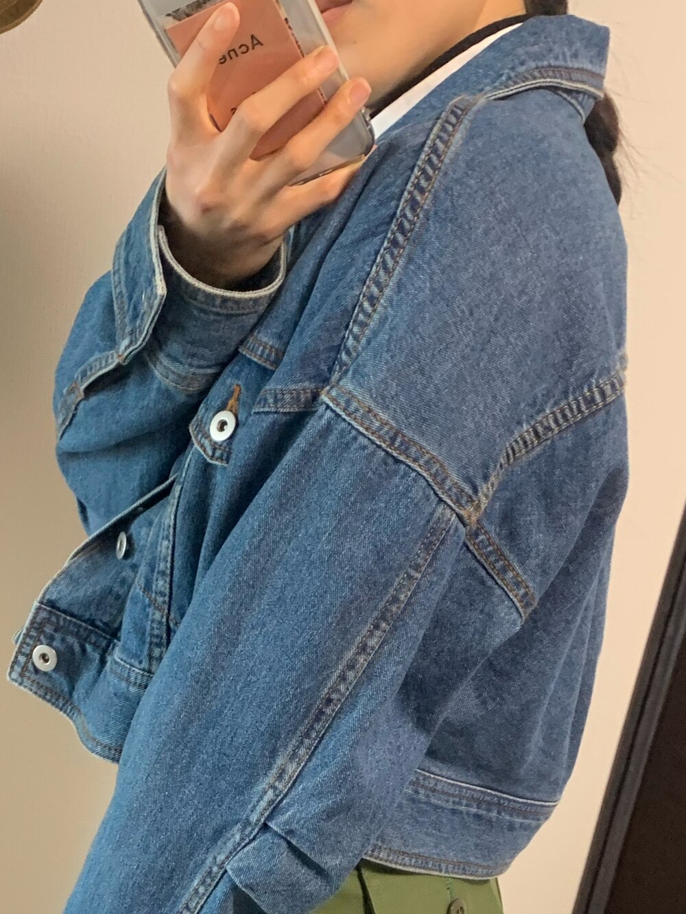 ホワイト系のシャツ/ブラウス、ブラック系のニット/セーター、ブルー系のデニムジャケットを着用したレディースの春コーディネートの2枚目の写真