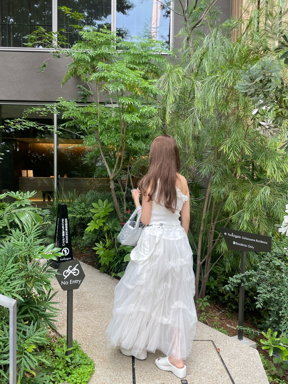 ホワイト系のジャンパースカート、ホワイト系のその他トップスを着用したレディースの夏コーディネートの4枚目の写真