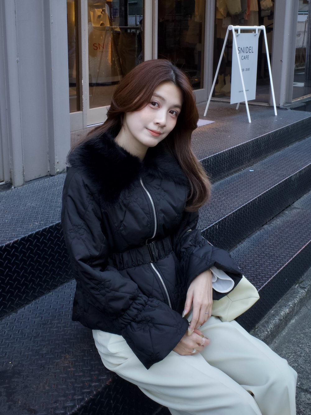 ブラック系のダウンジャケット/コートを着用したレディースの冬コーディネートの2枚目の写真