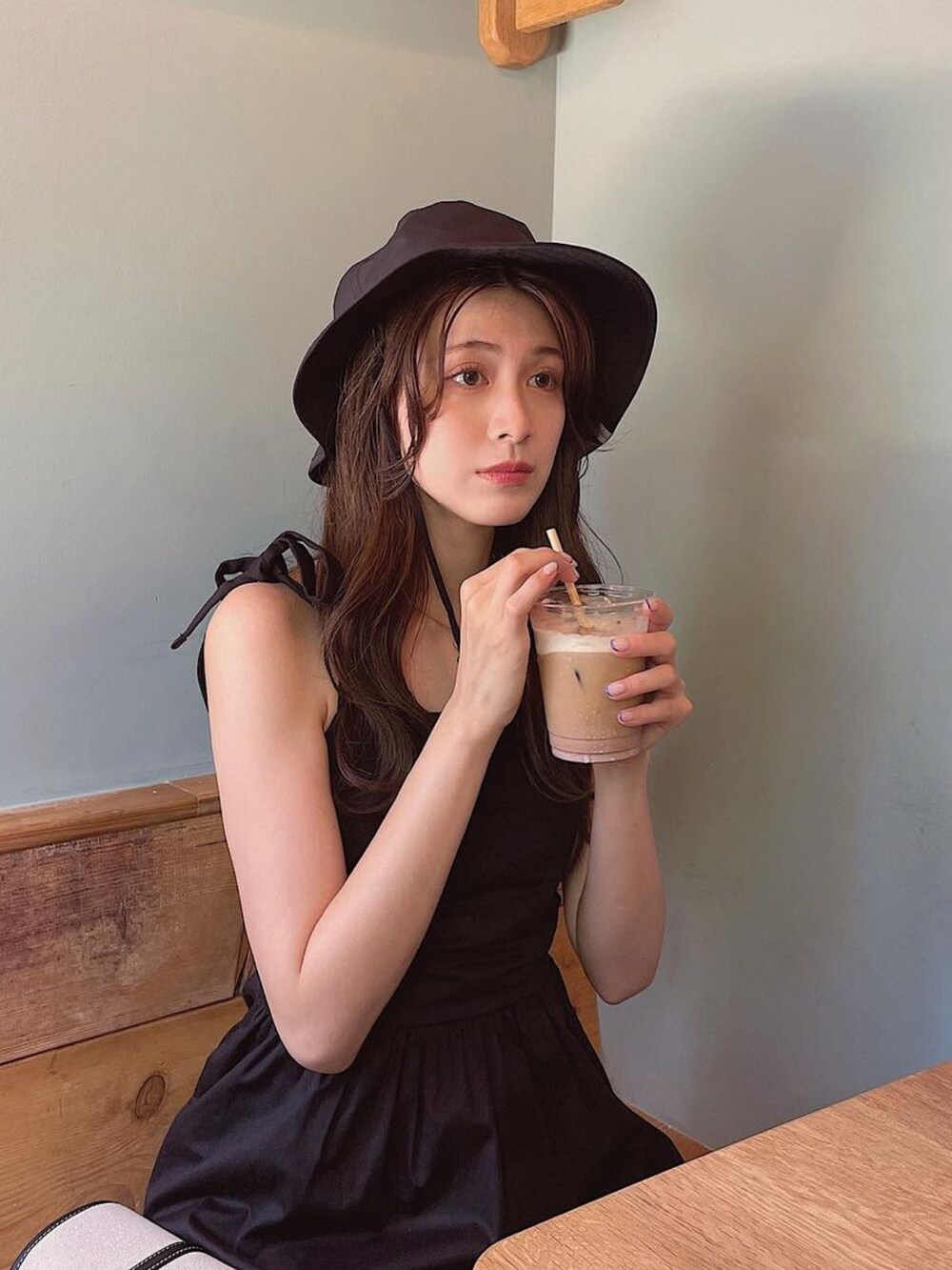 ブラック系のワンピース、ブラック系のハットを着用したレディースの夏コーディネートの3枚目の写真