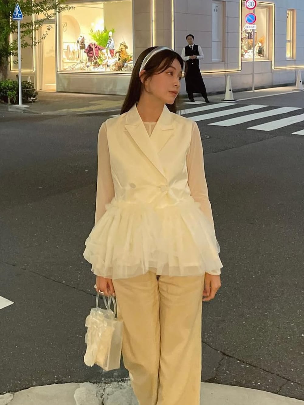 ホワイト系のジャケット/アウター、ホワイト系のトップス、ホワイト系のハンドバッグを着用したレディースの秋コーディネートの2枚目の写真