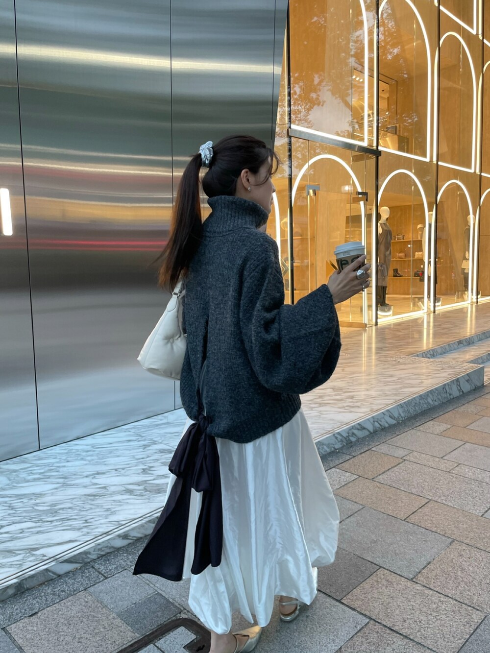 ブラック系のニット/セーターを着用したレディースの秋コーディネートの2枚目の写真