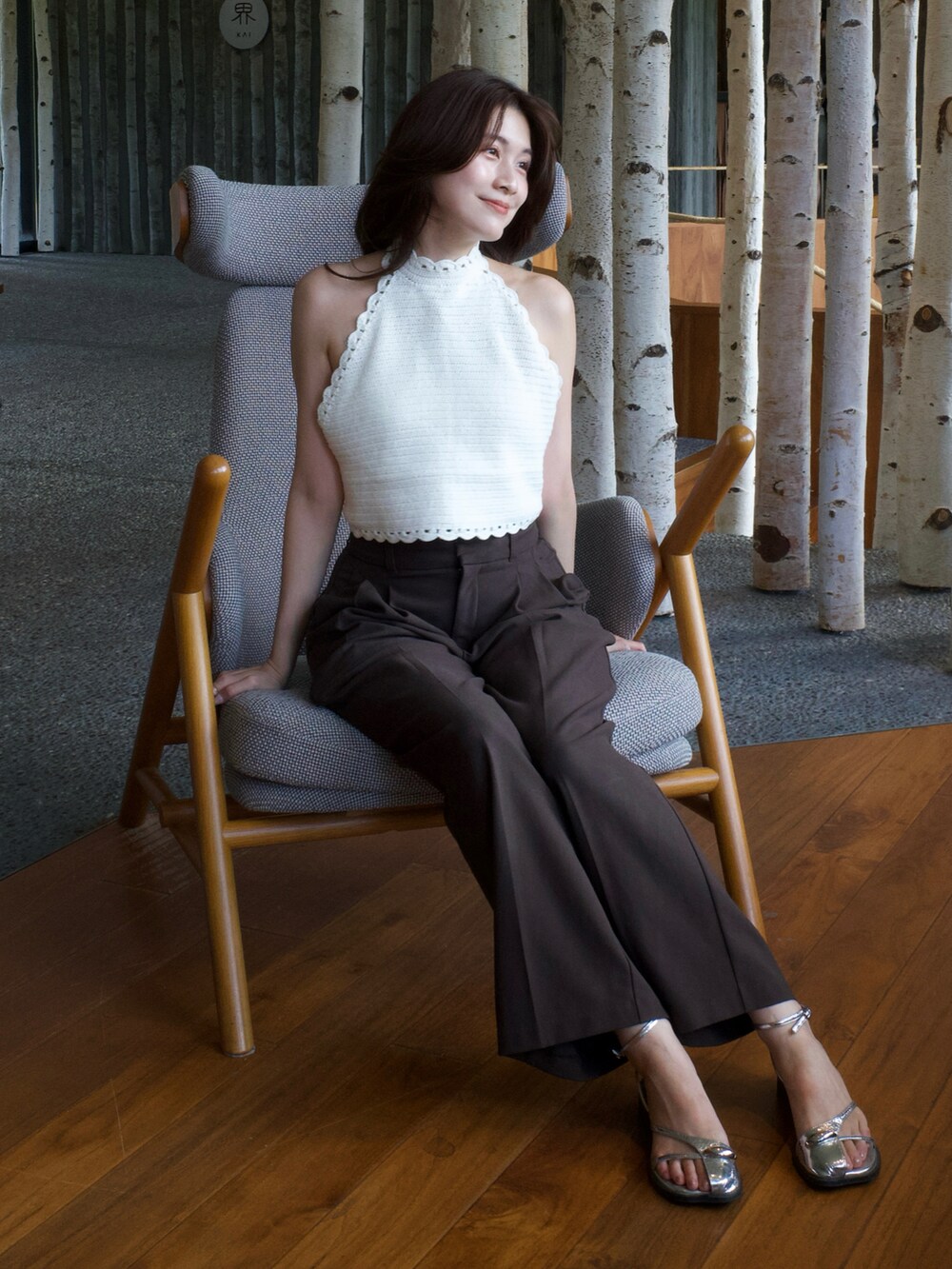 ホワイト系のニット/セーター、ブラウン系のパンツ、シルバー系のサンダルを着用したレディースの夏コーディネートの2枚目の写真