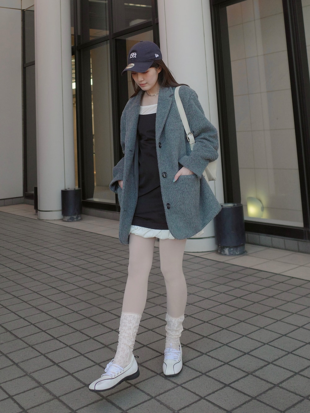 グレー系のテーラードジャケット、ホワイト系のスニーカーを着用したレディースの冬コーディネートの2枚目の写真